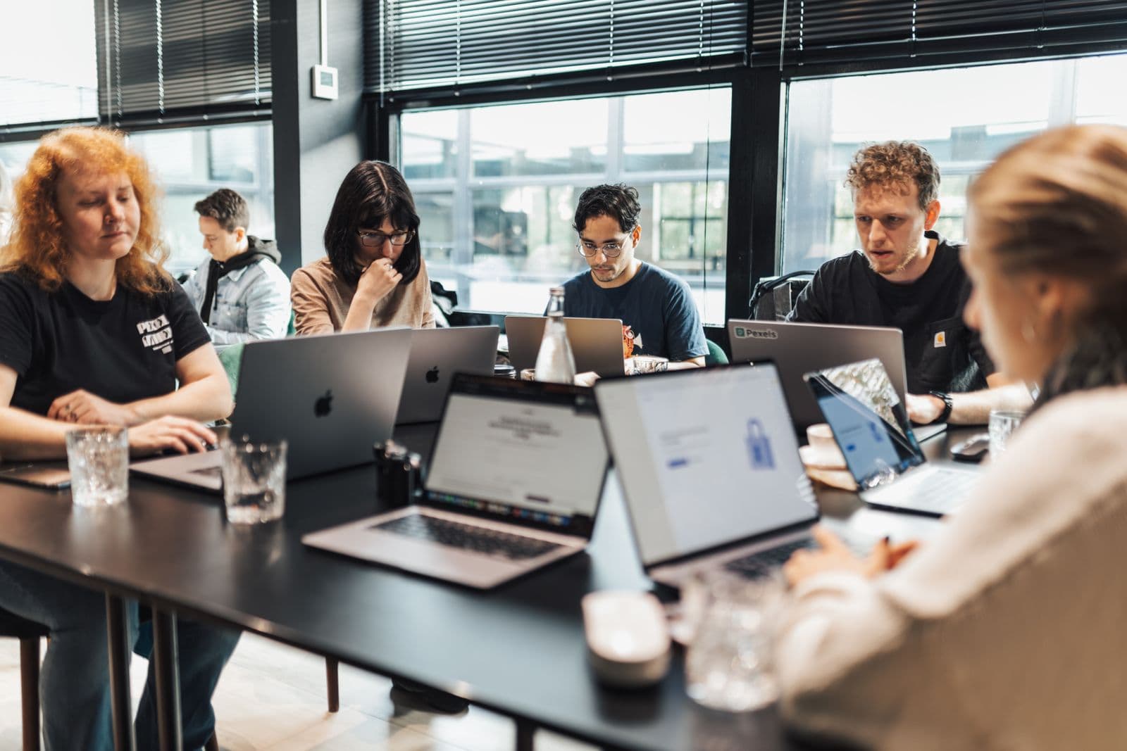 Professionals working on laptops during a training session at British Training Institute